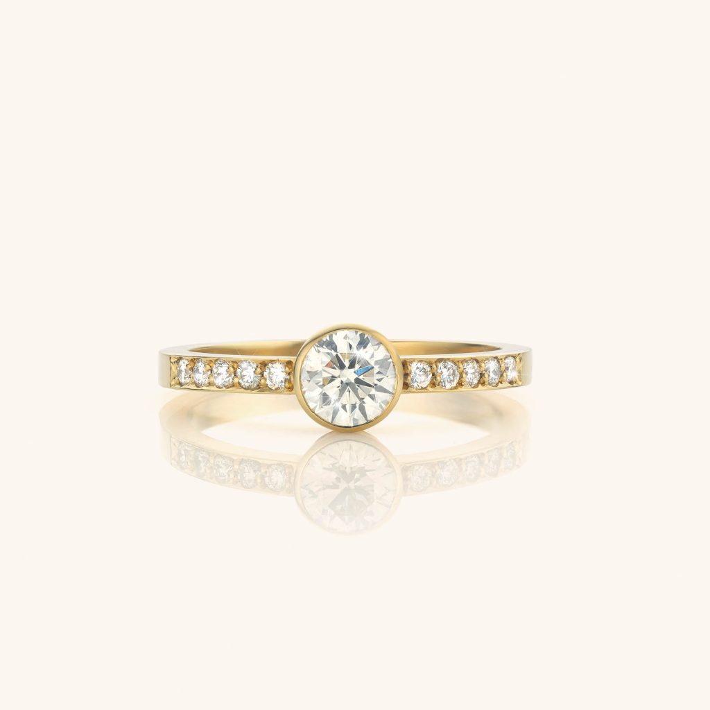 Unieke ring met centrale ronde diamant en filet gezette diamantjes in de ringband