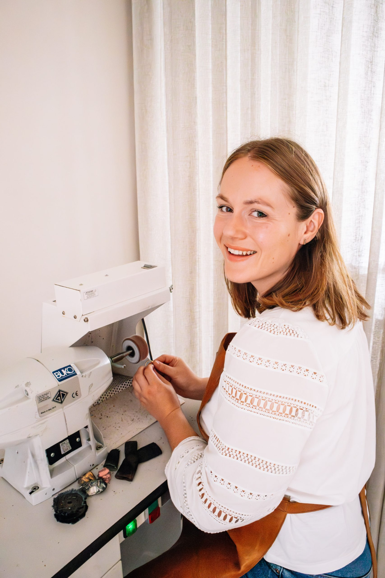 Marjolein polijst een handgesmeed juweel in het atelier